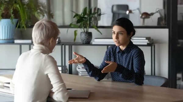 Two professional women speaking frankly at work talking about company culture