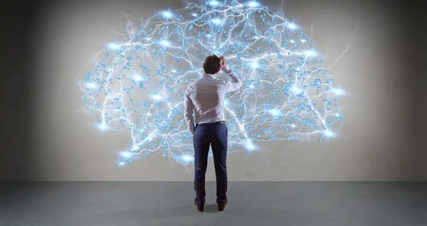 Man standing in front of an image of a brain culturewise culture operating system