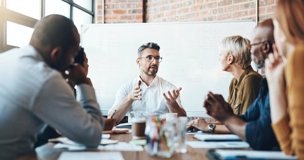 people seated at a work table debating ideas