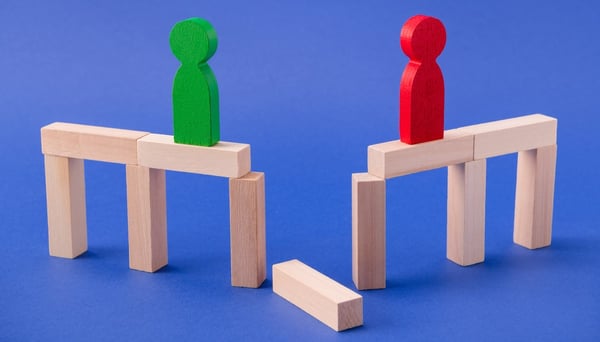 wooden figures on either side of a broken wooden block bridge