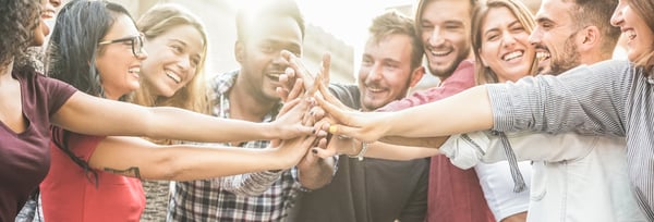 group of young workers clasping hands