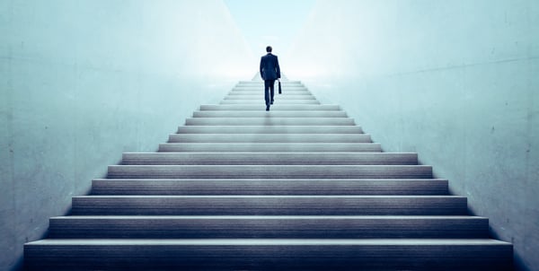 silhouette of a leader ascending stairway to exit