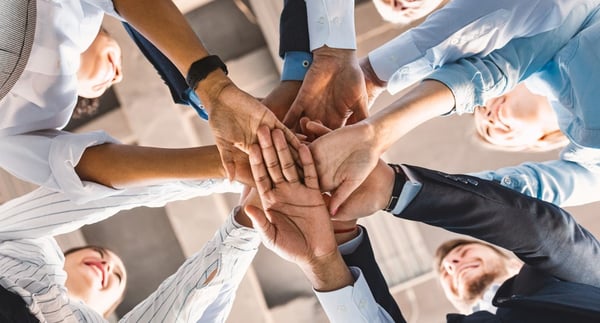 A group of hands coming together.